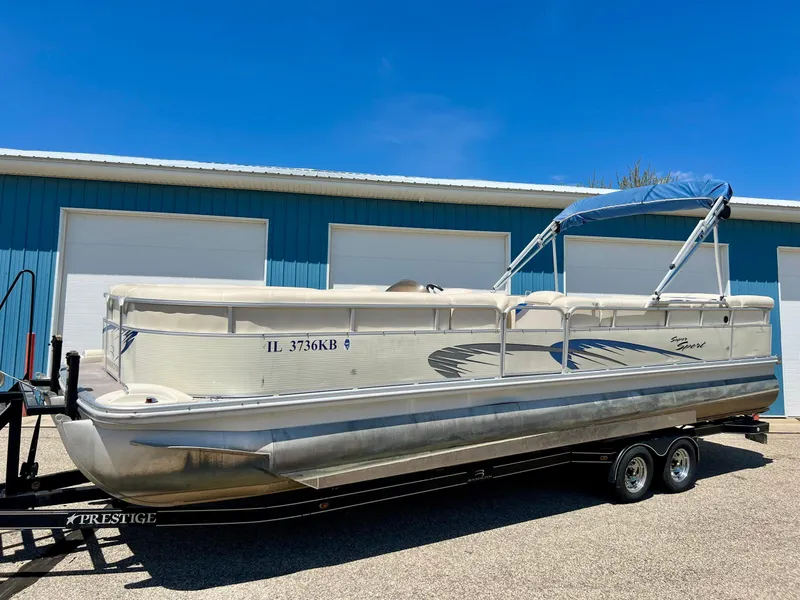 Slide: The Image of 2004 Bennington 2875RLX pontoon boat on trailer, parked near blue building. - 19