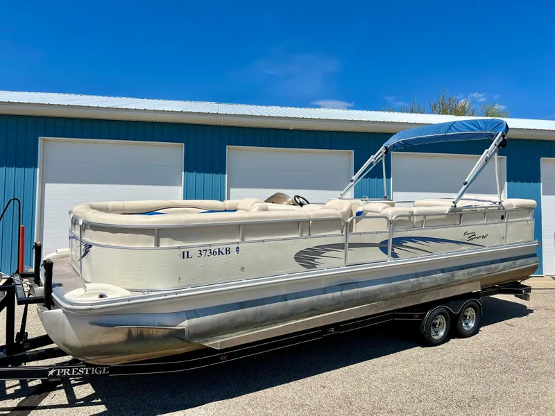 Slide: The Image of 2004 Bennington 2875RLX pontoon boat on trailer, parked near blue building. - 20
