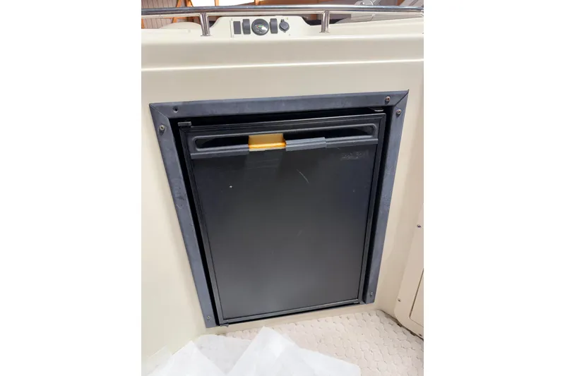 Slide: The Image of Built-in refrigerator on a 2004 Bennington 2875RLX boat, featuring a sleek black door. - 23