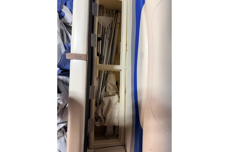 Slide: The Image of Storage compartment of a 2004 Bennington 2875RLX boat with poles and fabric. - 31