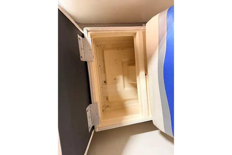 Slide: The Image of Open storage compartment in a 2004 Bennington 2875RLX boat, featuring a hinged lid. - 33