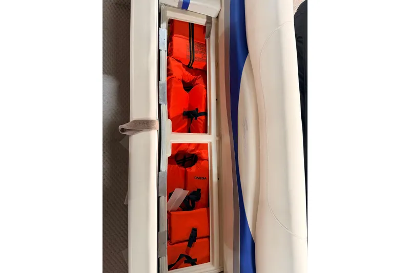 Slide: The Image of Storage compartment with orange life jackets on a 2004 Bennington 2875RLX boat. - 34