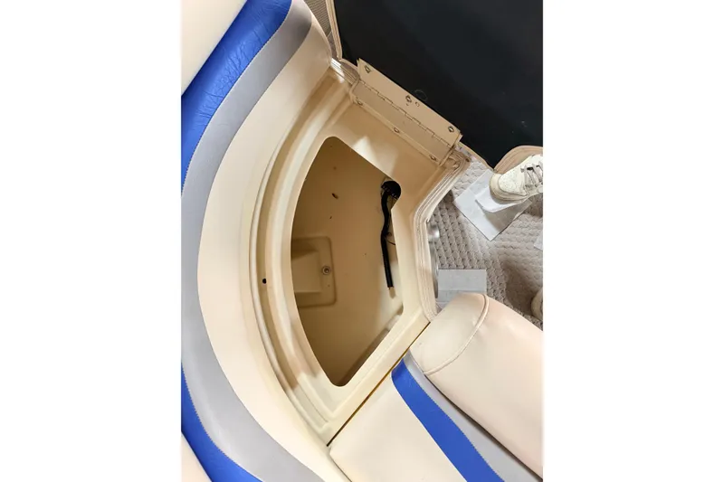 Slide: The Image of Open storage compartment in 2004 Bennington 2875RLX boat with beige and blue seating. - 36