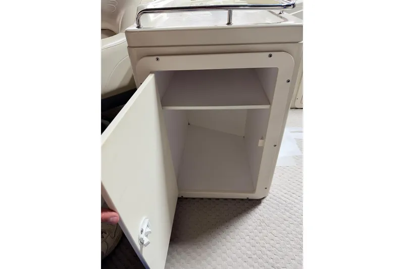 Slide: The Image of Open storage cabinet on 2004 Bennington 2875RLX boat, featuring a shelf and latch. - 41