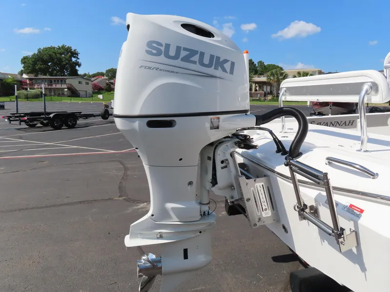 Slide: The Image of 2025 Savannah 220 IS boat with Suzuki outboard motor in a parking lot. - 11