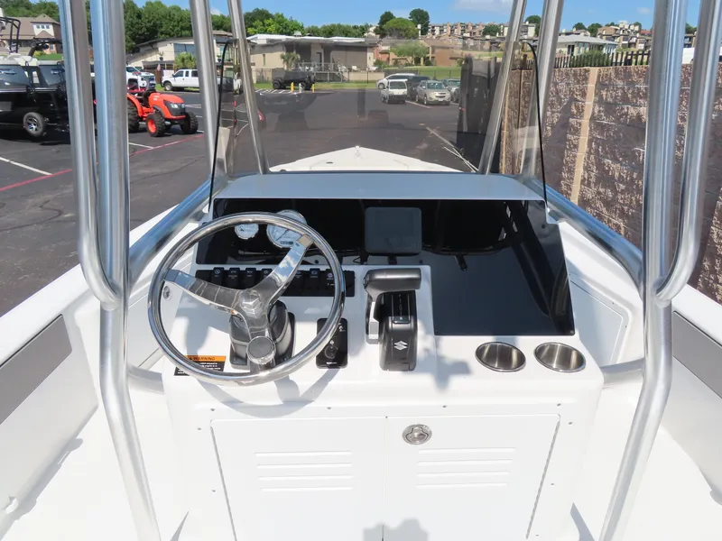 Slide: The Image of 2025 Savannah 220 IS boat console with steering wheel and controls, parked in a lot. - 5