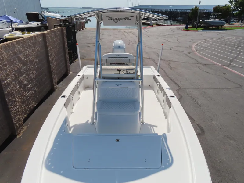 Slide: The Image of 2025 Savannah 220 IS boat at dock, showcasing spacious deck and sleek design. - 8