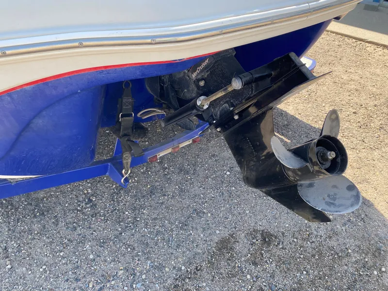 Slide: The Image of 2013 Tahoe Q5i boat stern with propeller and outboard motor on gravel. - 12