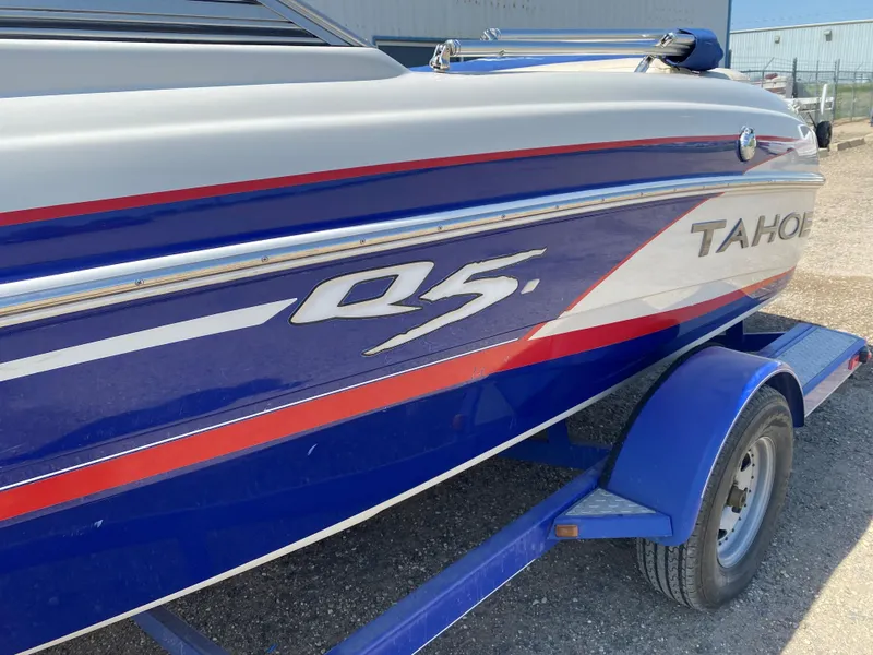 Slide: The Image of 2013 Tahoe Q5i boat on trailer, blue and white with red accents. - 3