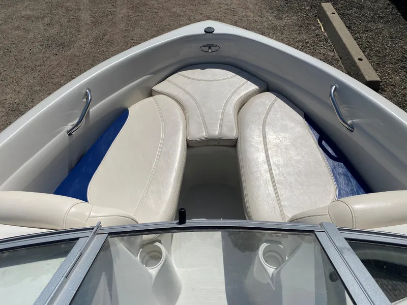 Slide: The Image of 2013 Tahoe Q5i boat interior with white cushioned seating and metal handrails. - 5