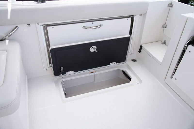 Slide: The Image of 2026 Sailfish 276 DC boat storage compartment with open hatch and sleek design. - 8
