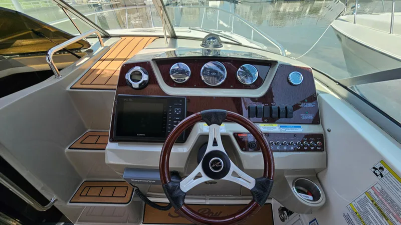 Slide: The Image of 2013 Sea Ray 280 Sundancer helm with steering wheel, gauges, and navigation system. - 15