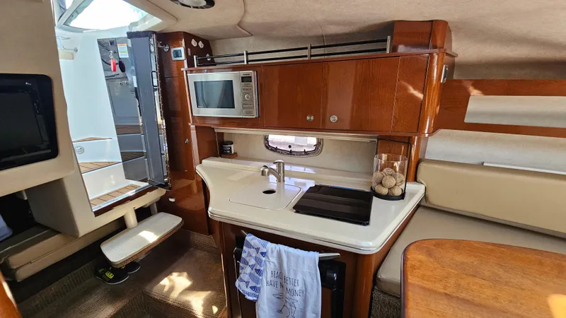 Slide: The Image of Interior of 2013 Sea Ray 280 Sundancer boat with kitchenette and seating area. - 21