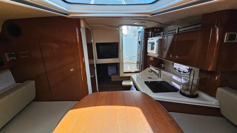 Slide: The Image of Interior of 2013 Sea Ray 280 Sundancer boat with kitchenette and seating area. - 22