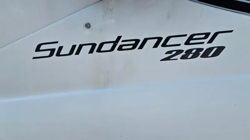 Slide: The Image of 2013 Sea Ray 280 Sundancer boat logo on white surface. - 30