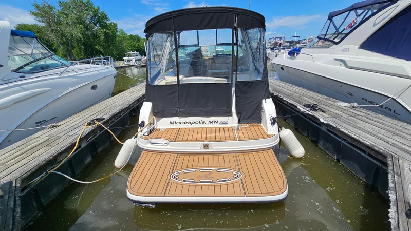 Slide: The Image of 2013 Sea Ray 280 Sundancer docked, featuring a spacious swim platform and black canopy. - 5