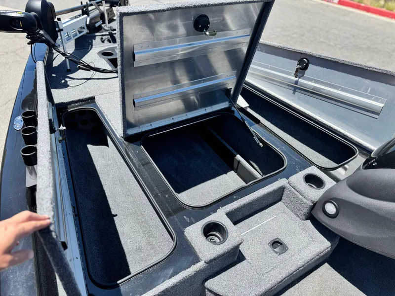 Slide: The Image of 2021 Tracker Pro Team 175 TXW boat with open storage compartments and fishing rod holders. - 13