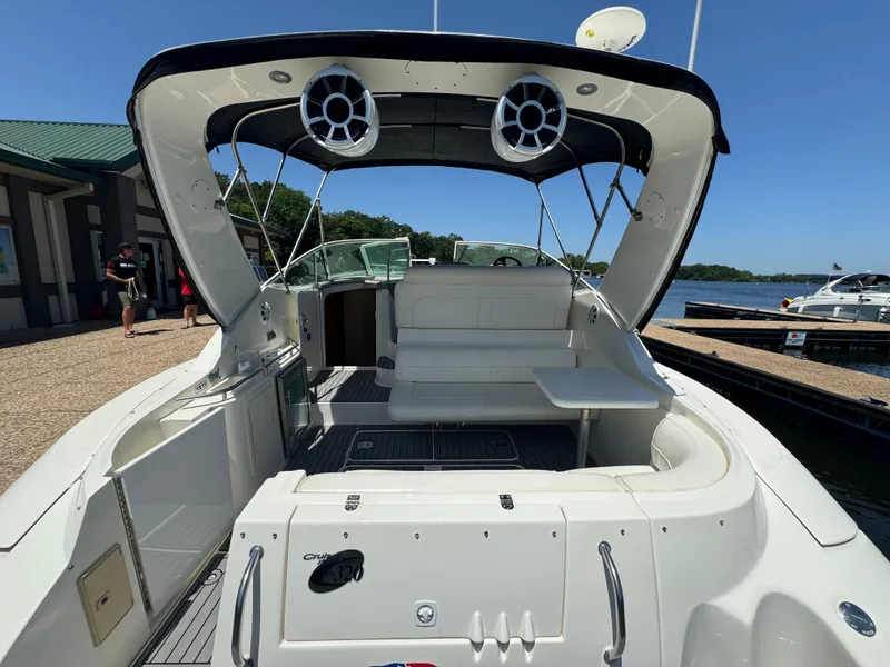 Slide: The Image of 2004 Cruisers Yachts 320 Express boat interior with seating and speakers, docked by the water. - 12