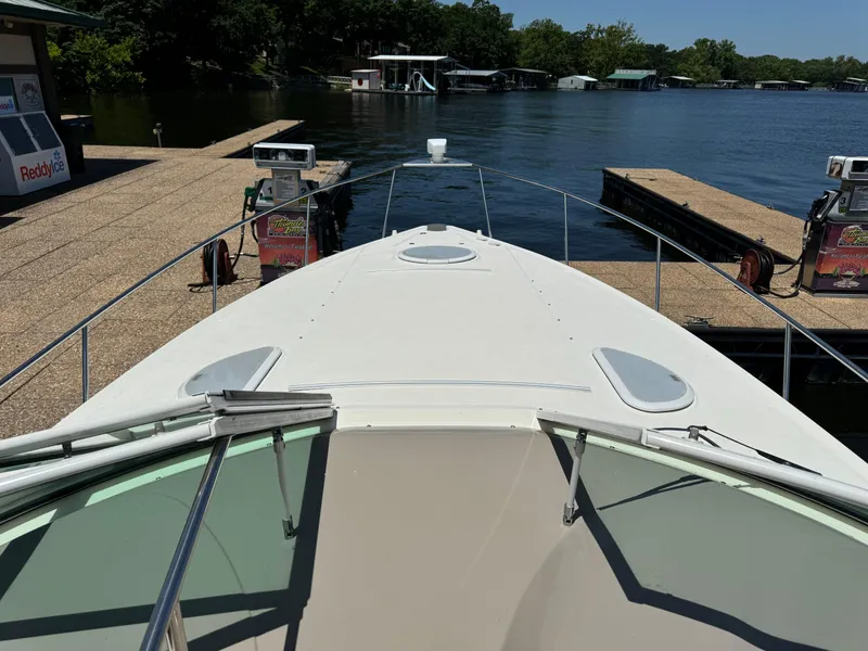 Slide: The Image of 2004 Cruisers Yachts 320 Express docked at a marina with clear water view. - 21
