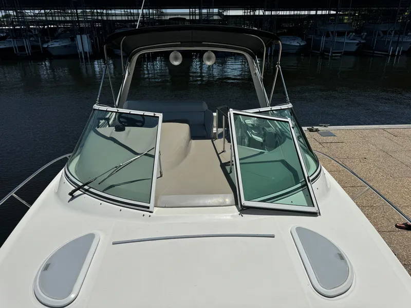 Slide: The Image of 2004 Cruisers Yachts 320 Express at dock, featuring open windshield and sleek design. - 24