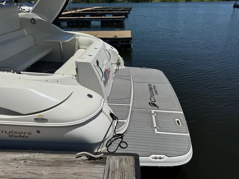 Slide: The Image of 2004 Cruisers Yachts 320 Express docked, showcasing spacious deck and seating area. - 9