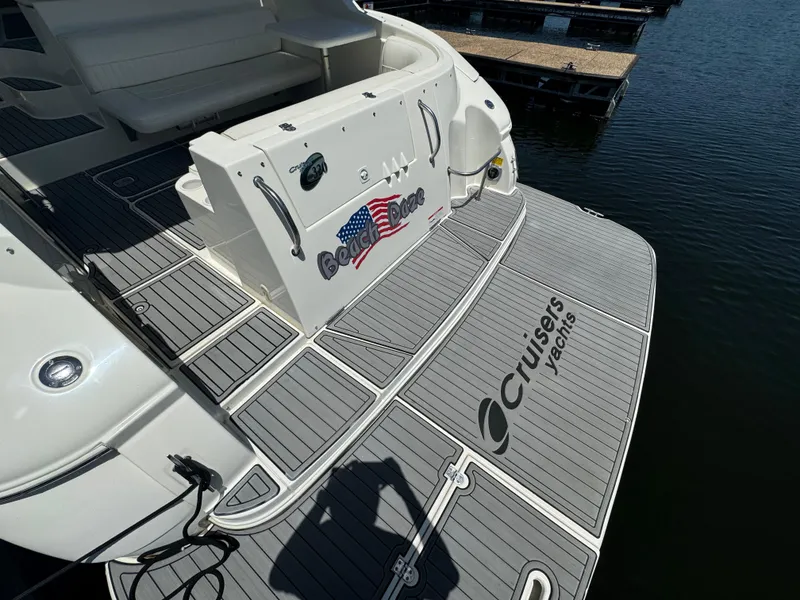 Slide: The Image of 2004 Cruisers Yachts 320 Express at dock, featuring sleek deck design and branding. - 10