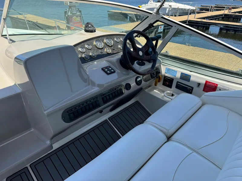 Slide: The Image of 2004 Cruisers Yachts 320 Express cockpit with steering wheel and control panel, dockside view. - 16
