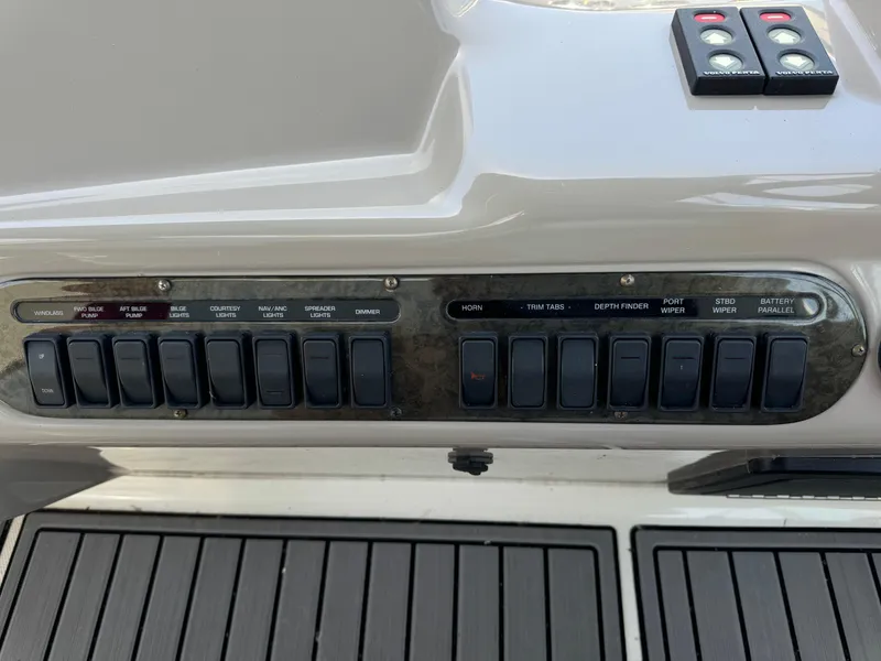 Slide: The Image of Control panel of a 2004 Cruisers Yachts 320 Express with labeled switches and buttons. - 17