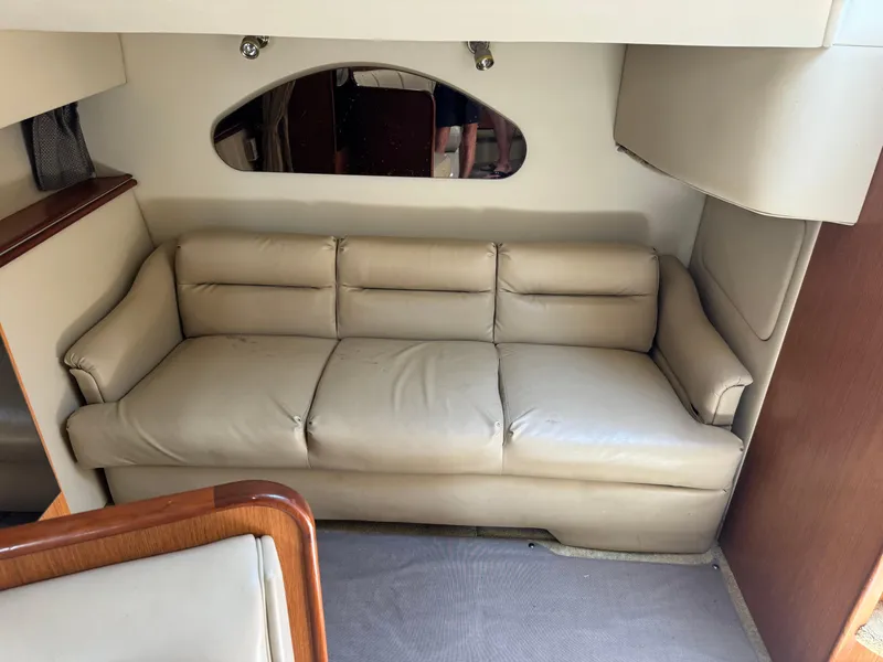 Slide: The Image of 2004 Cruisers Yachts 320 Express interior with beige leather sofa and wooden accents. - 28
