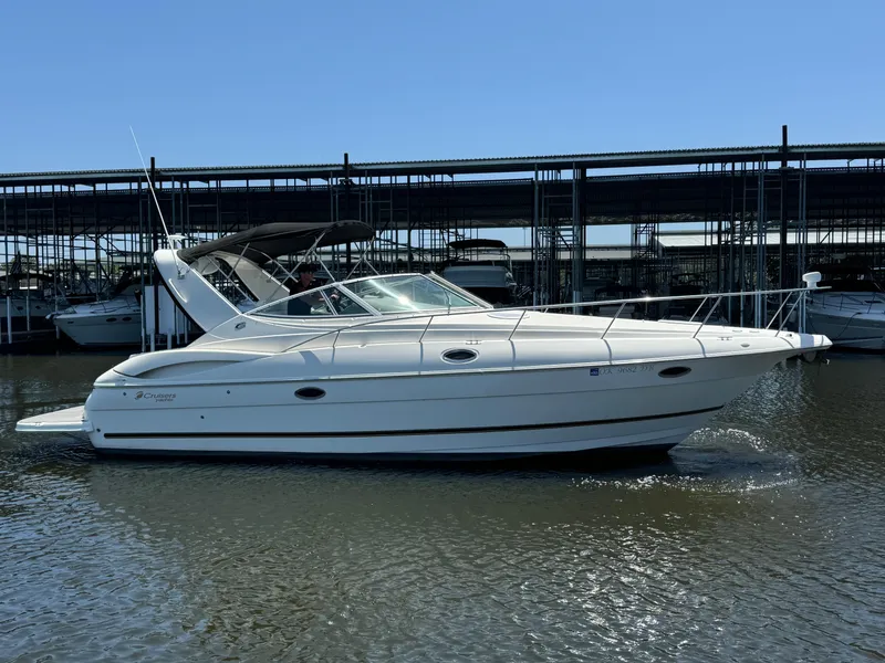 Slide: The Image of 2004 Cruisers Yachts 320 Express on water near marina, side view. - 3