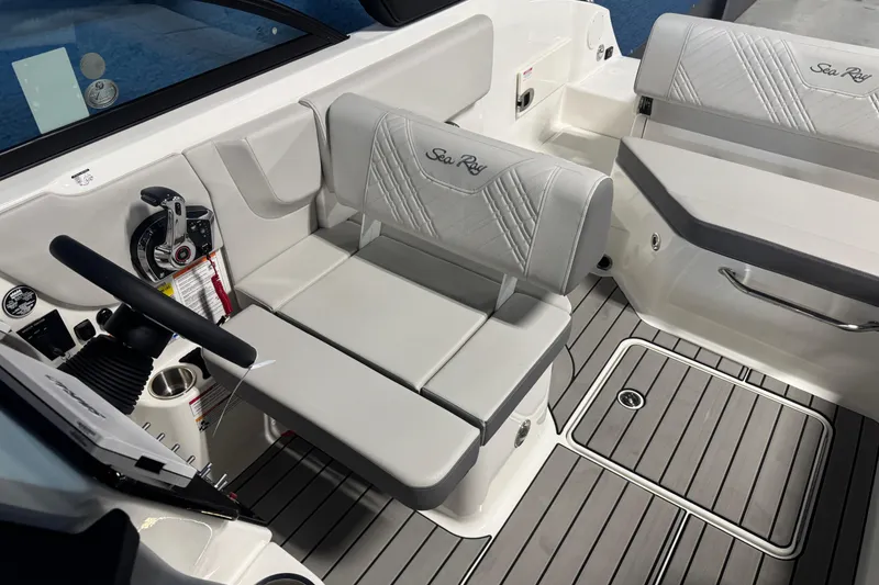 Slide: The Image of 2026 Sea Ray SDX 230 boat interior with gray seating and modern controls. - 12
