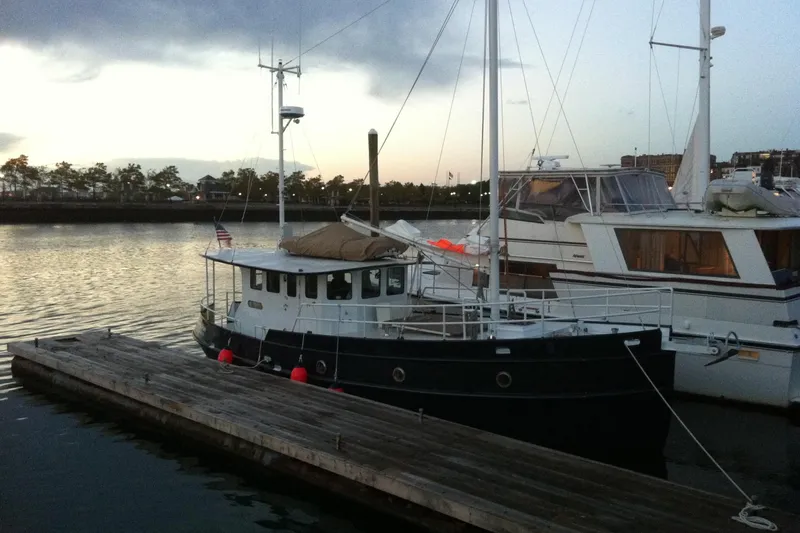 Slide: The Image of Custom 2012 Steel Trawler docked at sunset, with nearby boats and calm water. - 1