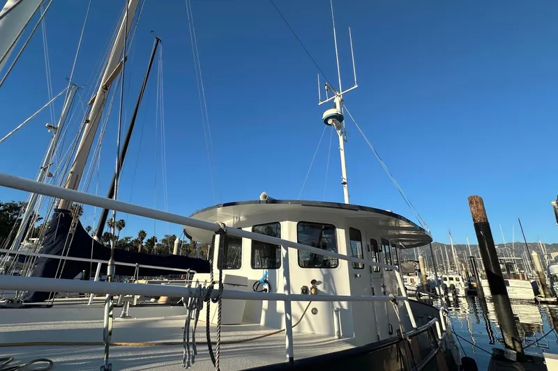 Slide: The Image of Custom 2012 Steel Trawler docked in marina under clear blue sky. - 16
