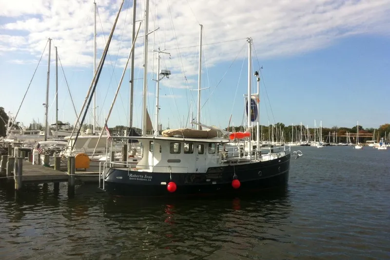 Slide: The Image of Custom 2012 Steel Trawler docked at marina under blue sky. - 2