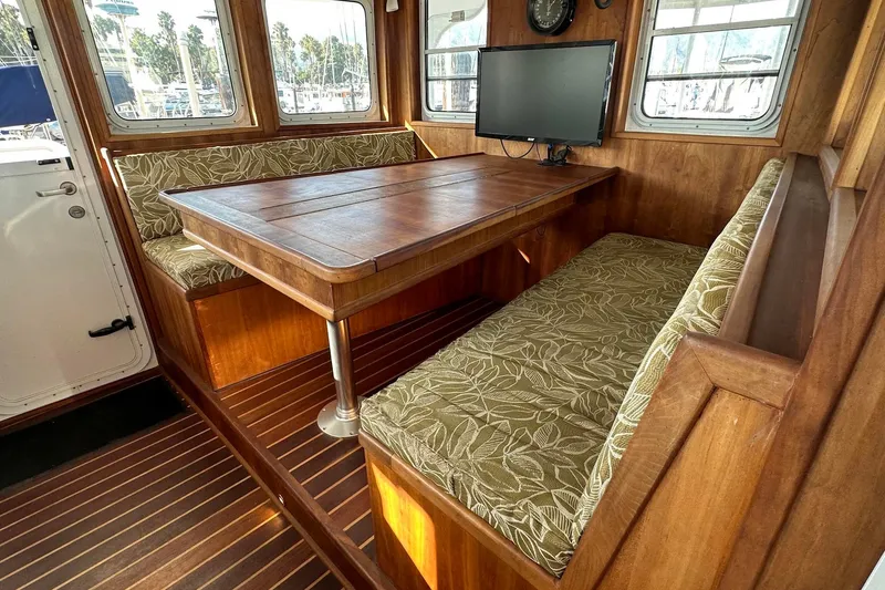 Slide: The Image of Cozy interior of 2012 Custom Steel Trawler with wooden table and patterned seating. - 26
