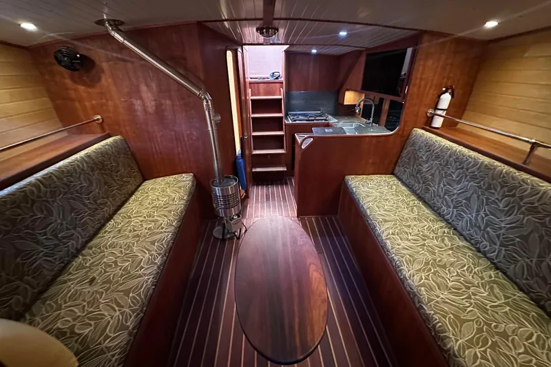 Slide: The Image of Interior of 2012 Custom Steel Trawler with wood finish, seating, and kitchenette. - 31
