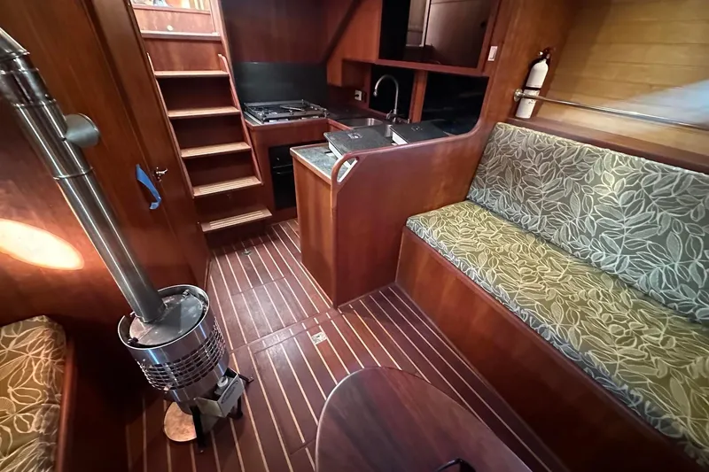 Slide: The Image of Interior of 2012 Custom Steel Trawler with wood finish, stove, and patterned seating. - 33