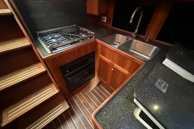 Slide: The Image of Custom 2012 Steel Trawler kitchen with stove, double sink, and wooden cabinetry. - 46