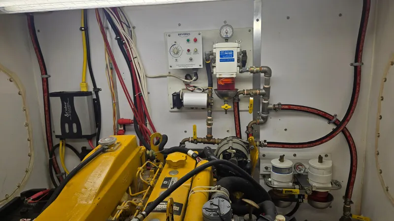 Slide: The Image of Engine room of a 2012 Custom Steel Trawler with visible machinery and wiring. - 52