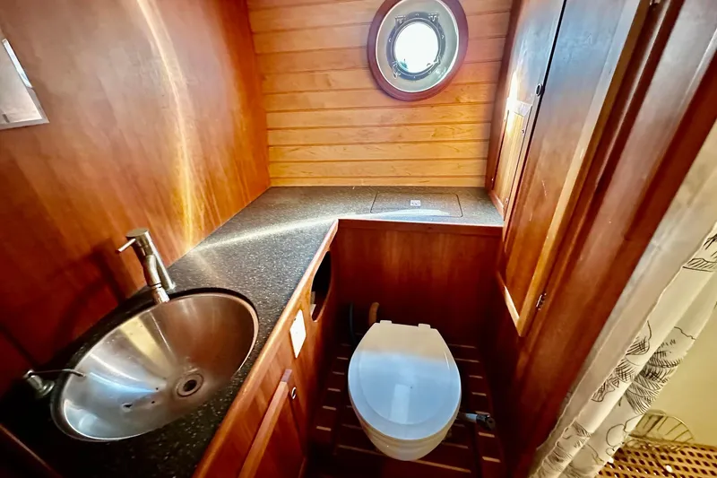 Slide: The Image of Custom Steel Trawler 2012 bathroom with wooden paneling, round sink, and porthole window. - 65