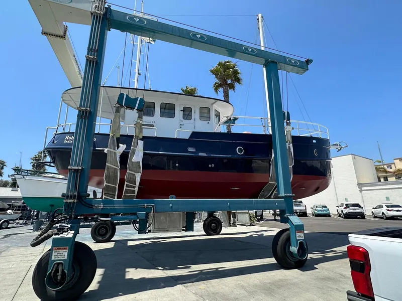 Slide: The Image of Custom 2012 Steel Trawler lifted by boat hoist in marina setting. - 7