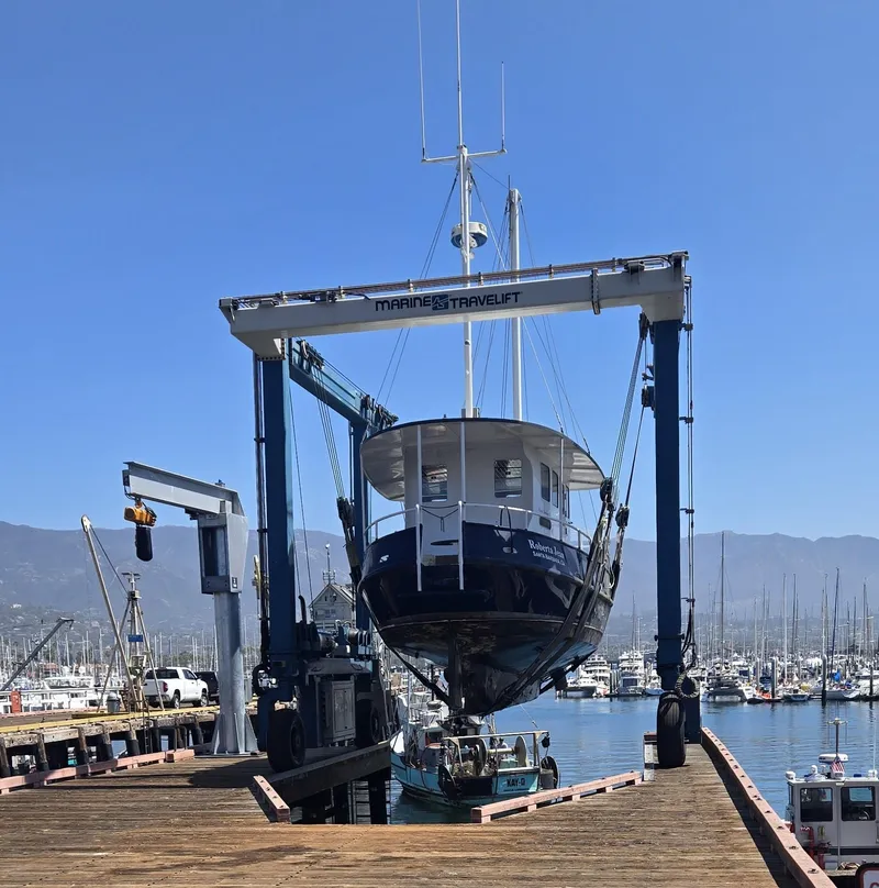 Slide: The Image of Custom 2012 Steel Trawler on a Marine Travelift at a marina, clear blue sky. - 9