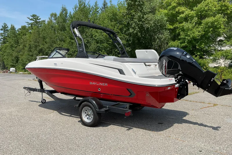 Slide: The Image of 2025 Bayliner VR5 OB boat with red hull on a trailer, parked outdoors. - 6