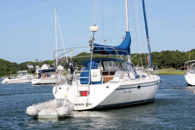 Slide: The Image of 1998 Catalina 42 MkII sailboat anchored in a scenic harbor with surrounding boats. - 10