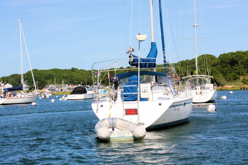 Slide: The Image of Sailboats anchored in a scenic harbor, featuring a 1998 Catalina 42 MkII. - 11