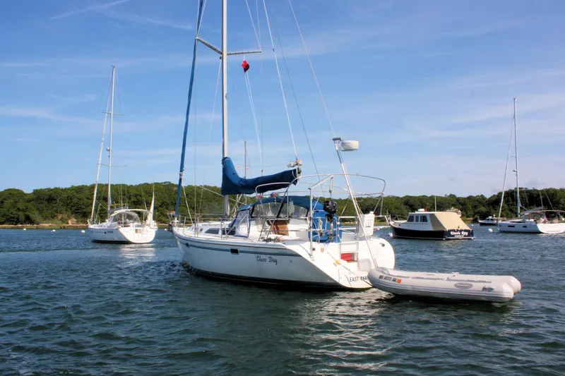 Slide: The Image of Sailboats anchored in a serene bay, featuring a 1998 Catalina 42 MkII. - 12