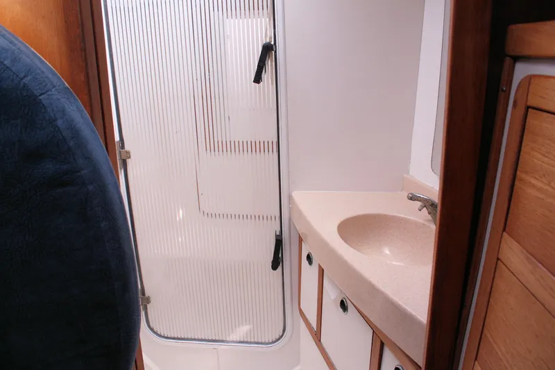 Slide: The Image of Bathroom interior of a 1998 Catalina 42 MkII yacht, featuring a sink and shower area. - 27