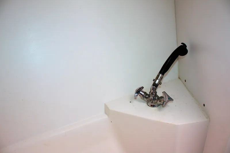 Slide: The Image of Boat plumbing fixture in a 1998 Catalina 42 MkII, featuring a chrome valve and black hose. - 29