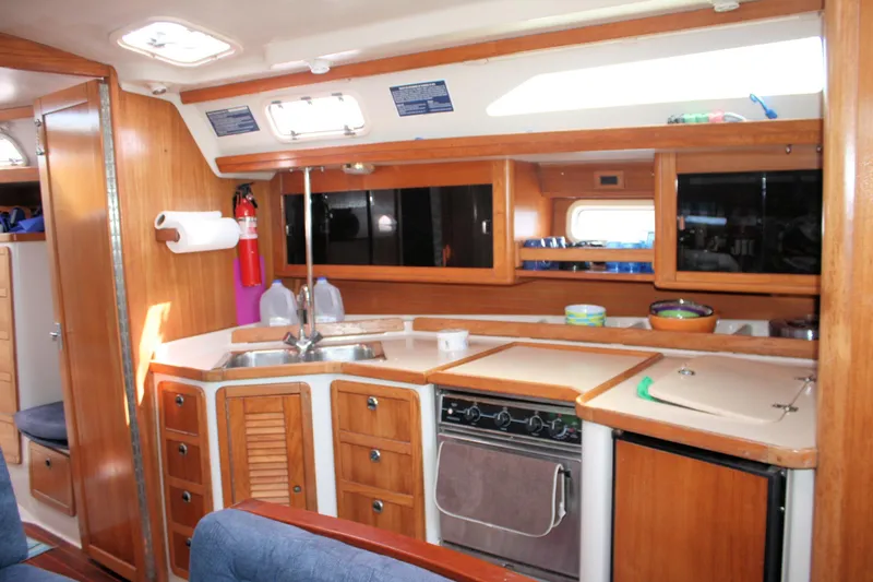 Slide: The Image of Interior of 1998 Catalina 42 MkII sailboat, featuring a well-equipped wooden galley kitchen. - 35