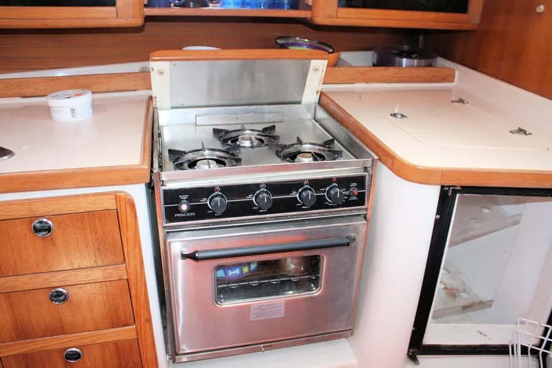 Slide: The Image of Galley kitchen in 1998 Catalina 42 MkII yacht with stove and wooden cabinetry. - 38